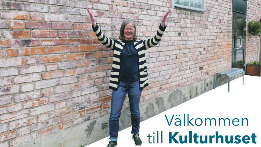 Lena Hallström Framför en vägg och texten "Välkommen till Kulturhuset"