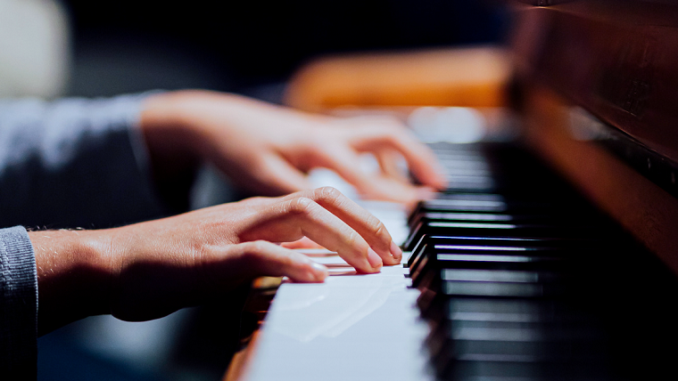Händer som selar på ett piano. 