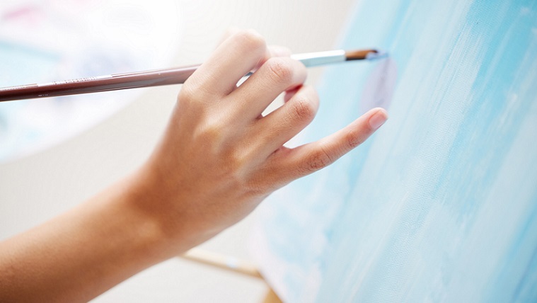 hand målar med pensel på en canvas. 