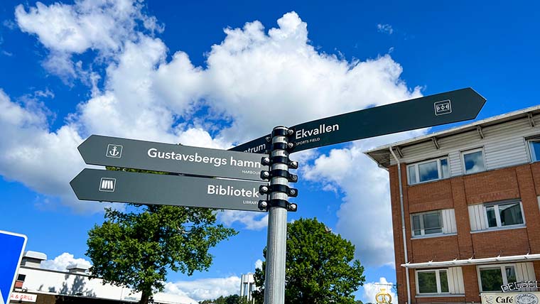 En stolpe med flera olika pilskyltar i Gustavsbergs centrum.